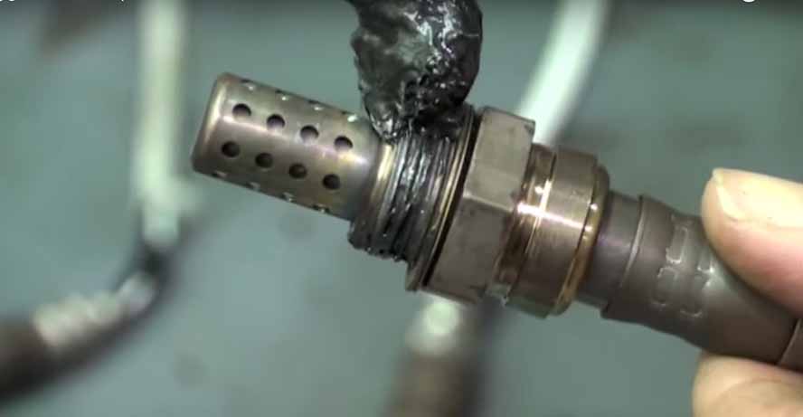 Anti-seize being added to O2 sensor threads