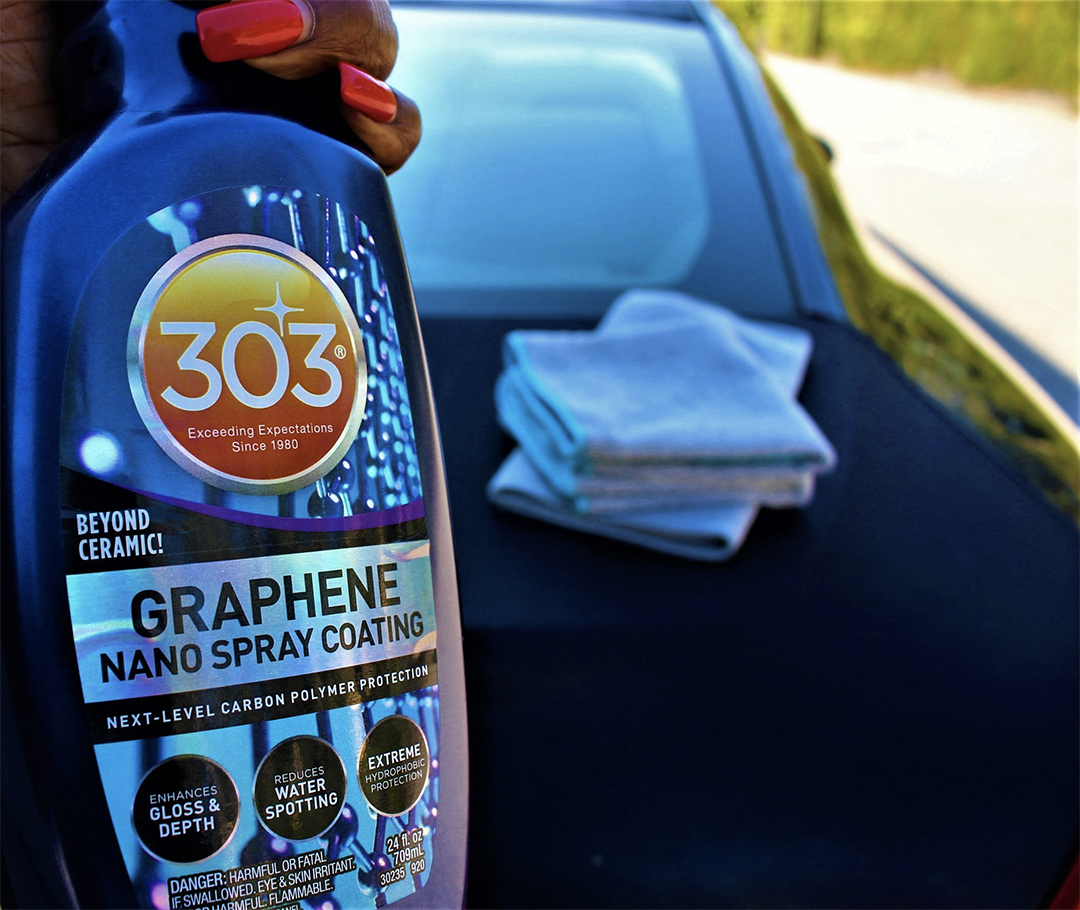 closeup of a bottle of 303 Graphene Nano Spray held by a woman's hand with bright red nails