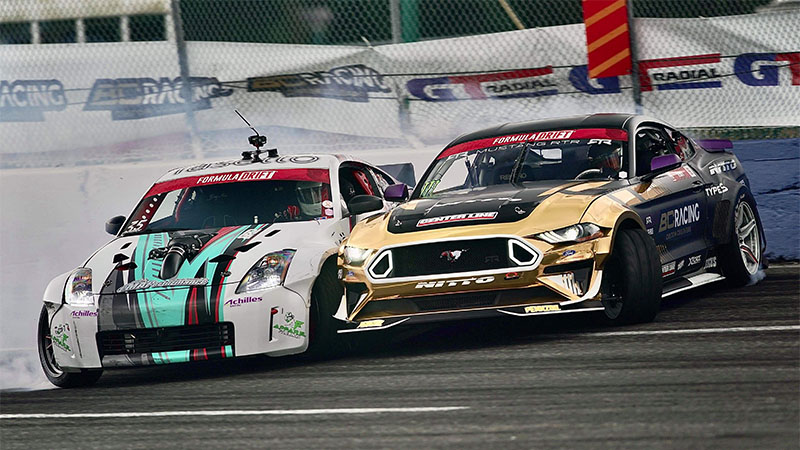 two cars side by side drifting