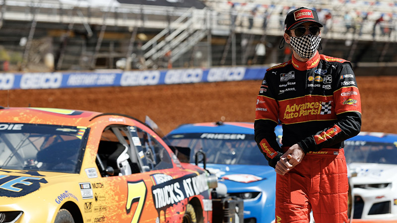 Ryan Blaney walks past a row of race cars