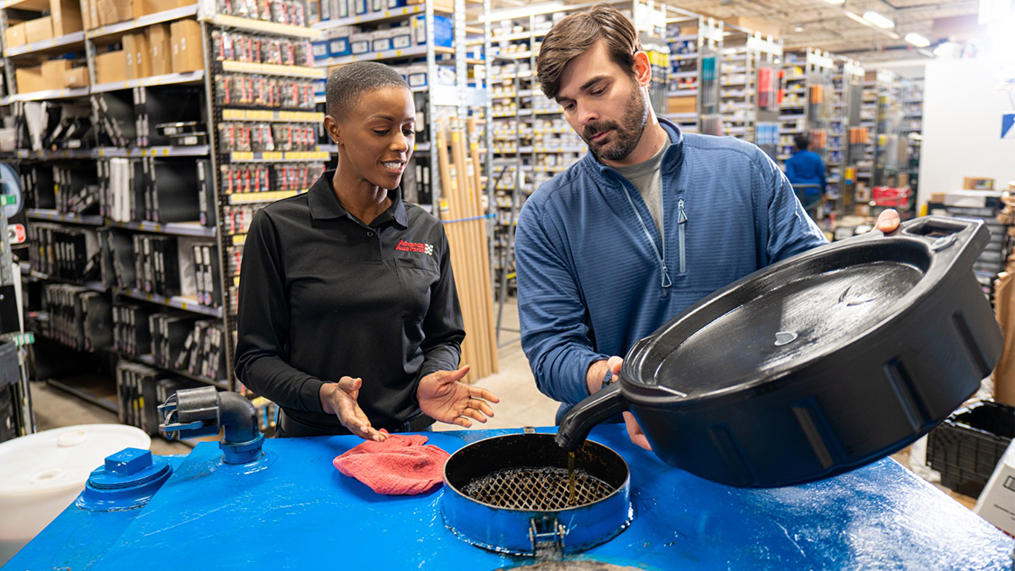 Customer recycling oil with AAP team member 