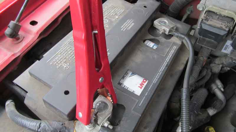 connect red jumper cable on dead battery