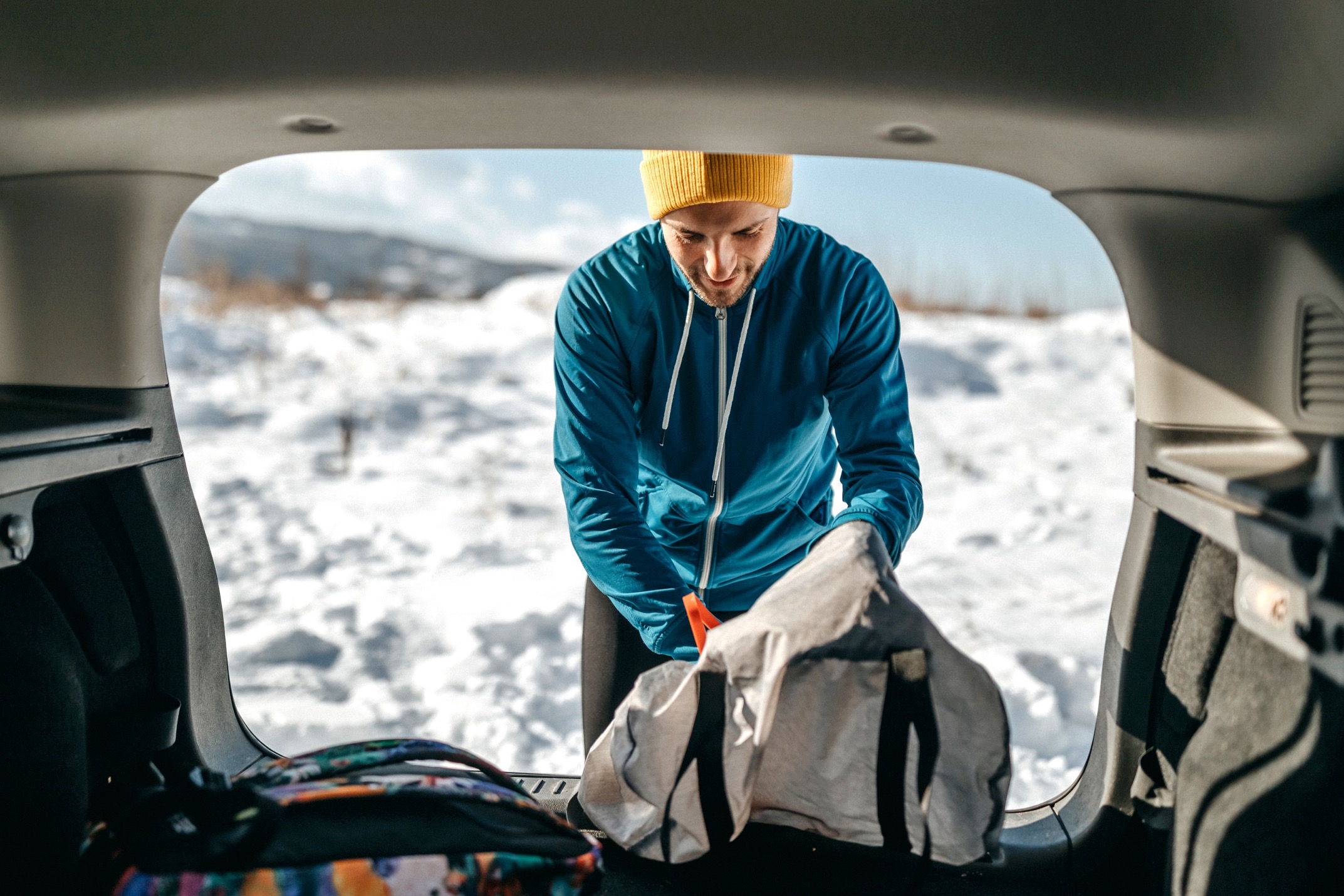 Person taking winter car accessories out of bag