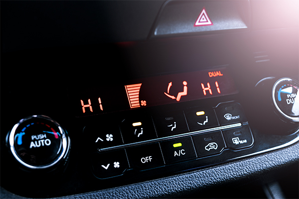 A close up view of a vehicle's A/C controls set to high