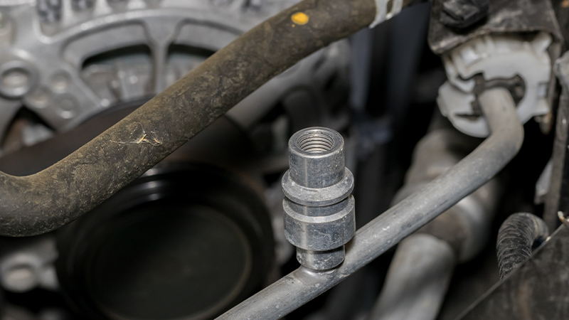 A closeup view of an A/C service port with the cap removed