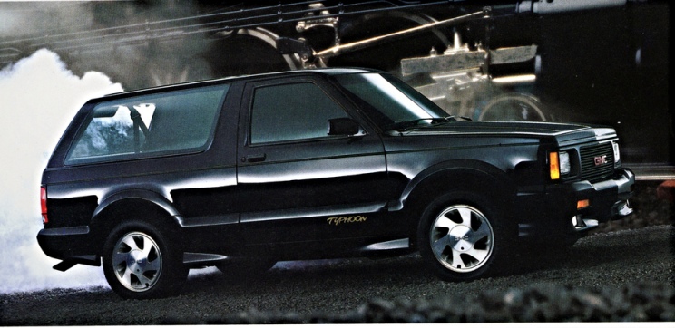 black typhoon SUV races alongside a steam train