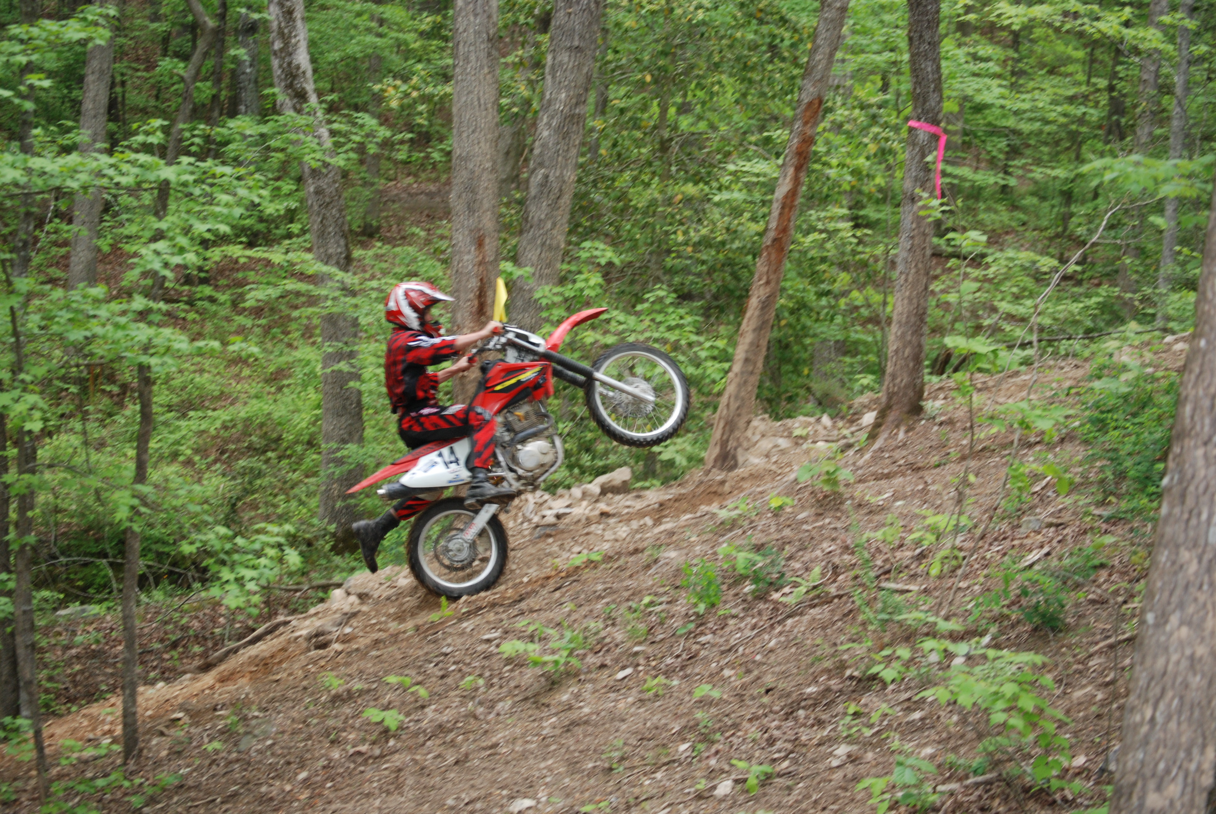 man riding dirt bike up a hill