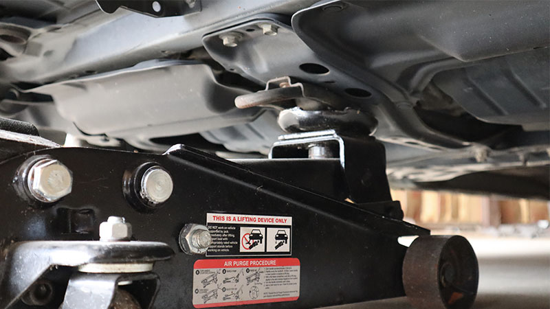 safe placement of a floor jack on the front of a vehicle