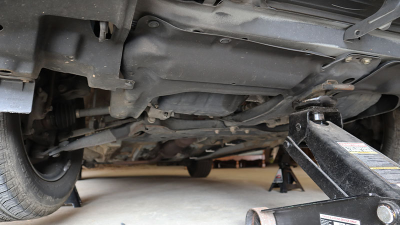 jack in raised position under the front of the vehicle