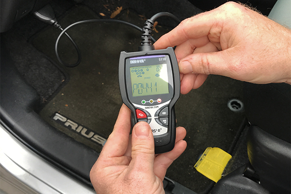 obd-ii code reader connected to the port in a vehicle