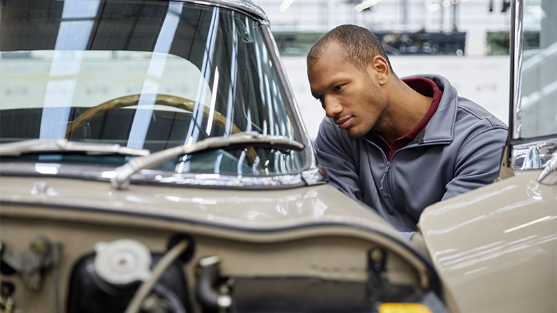 a man inspecting a classic car