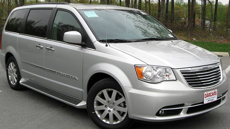 A silver minivan in a parking lot.