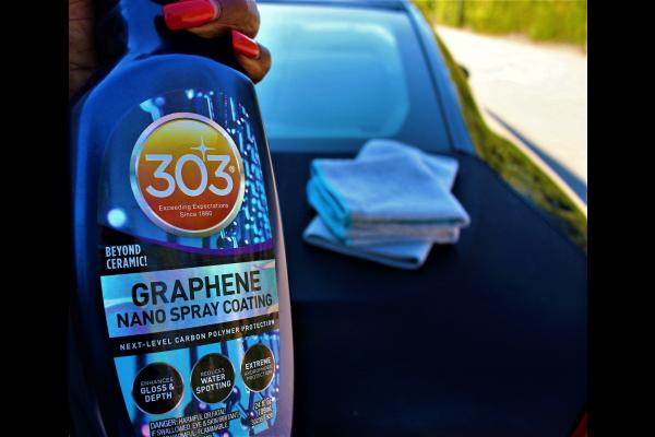 closeup of a 303 Graphene Nano Spray bottle held by a woman's hand with bright red nails