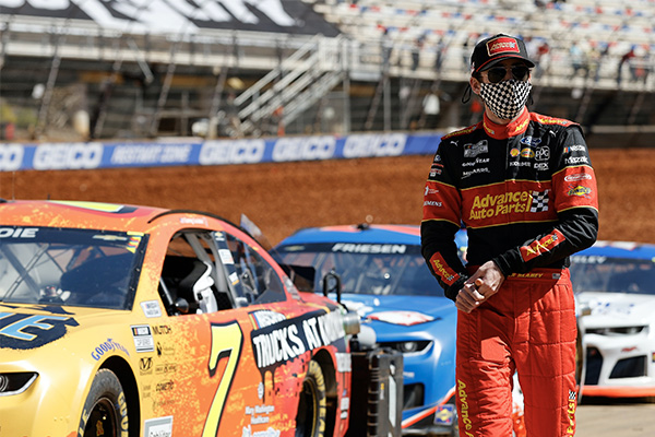 Ryan Blaney walking next to racecars on track | Source: Penske