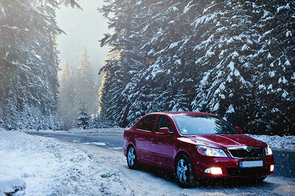 red car driving through snow