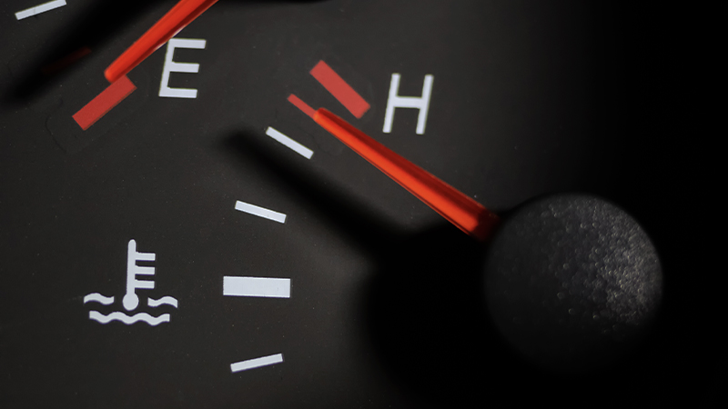 A temperature gauge in the instrument cluster shows the engine is overheating